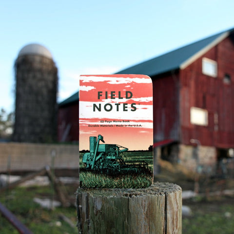Memo book with image of combine harvester sitting on fence post