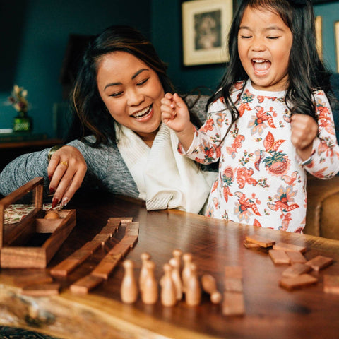 child and women playing table top bowling game
