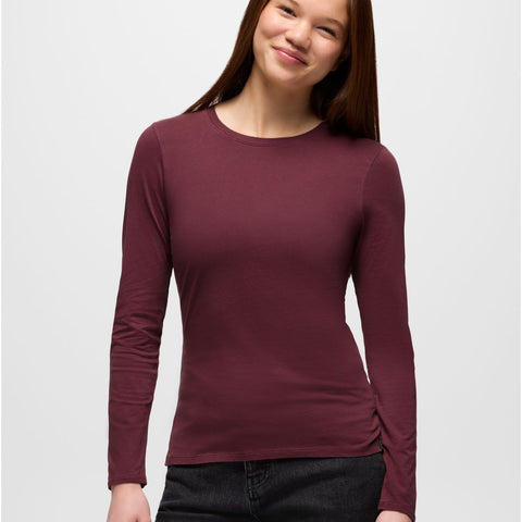 Woman wearing a maroon long-sleeve shirt against a white background