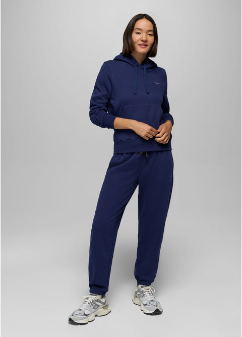Person wearing a navy blue hoodie and pants set on a light gray background