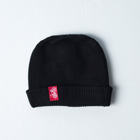 Black dock beanie with red sewn on bicycle tag